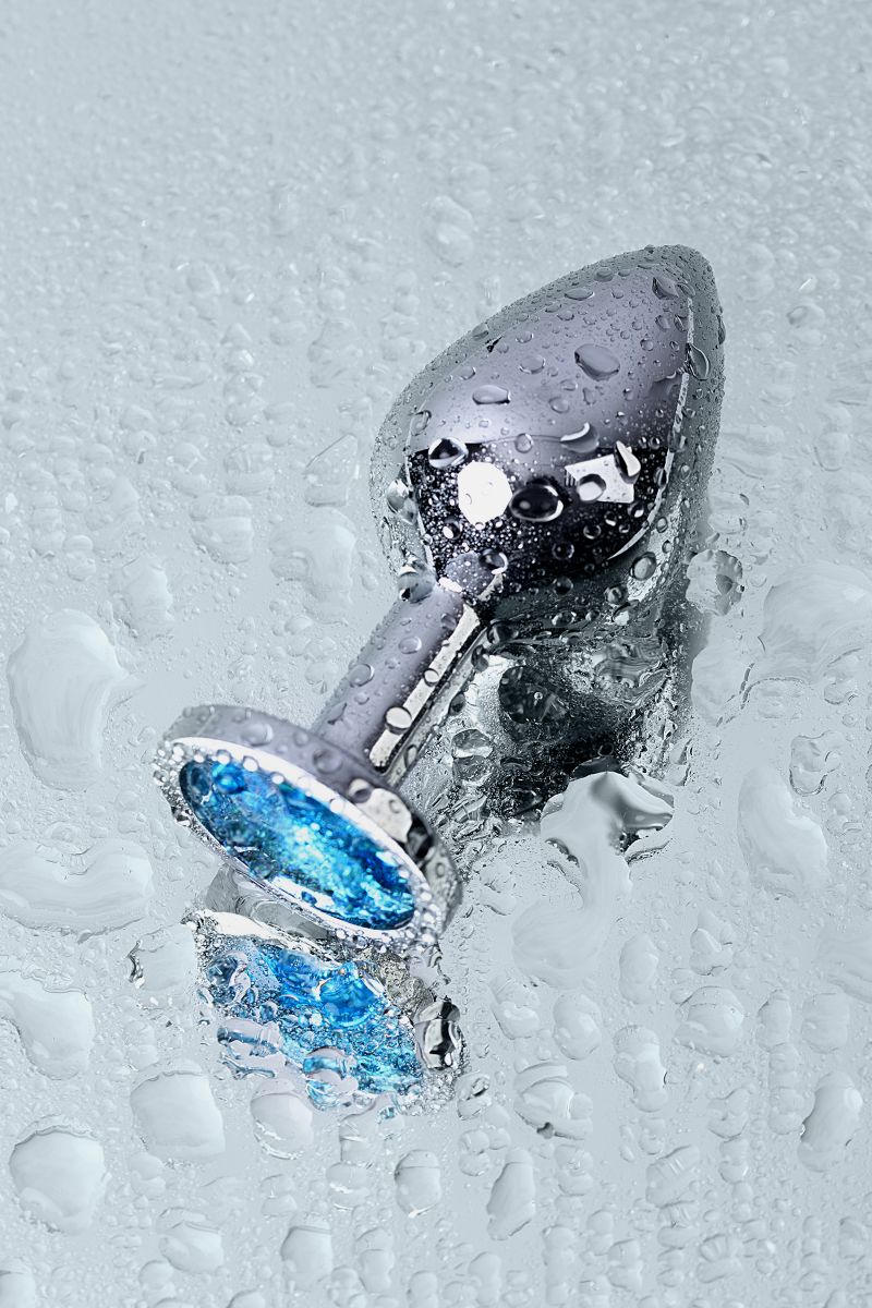 Серебристая конусовидная анальная пробка с голубым кристаллом - 8 см. 